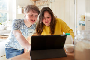 To ungdommer med utviklingshemning ser på en PC-skjerm sammen